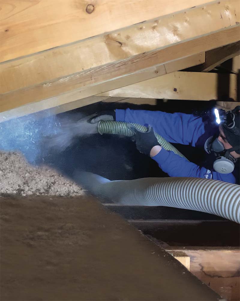 Blown-In attic insulation installer, in attic